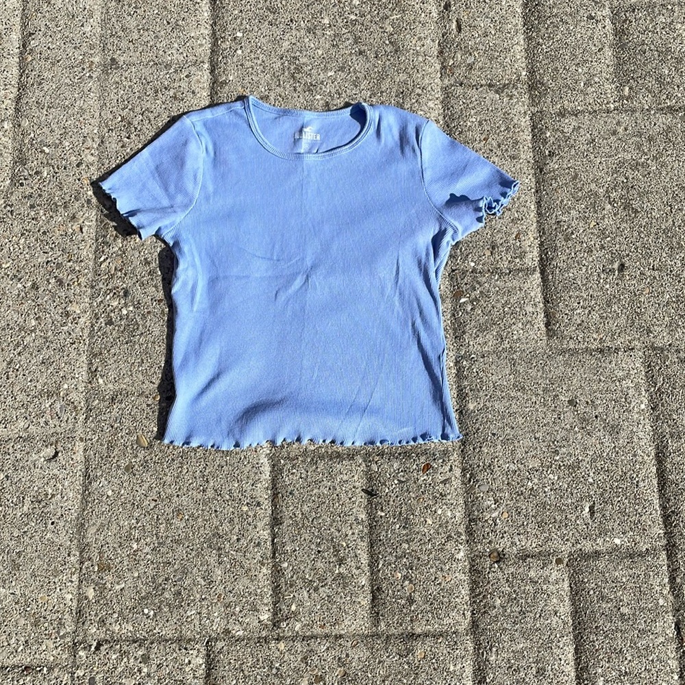 Blue fitted Hollister short sleeve shirt with ruffles around the bottom/sleeves